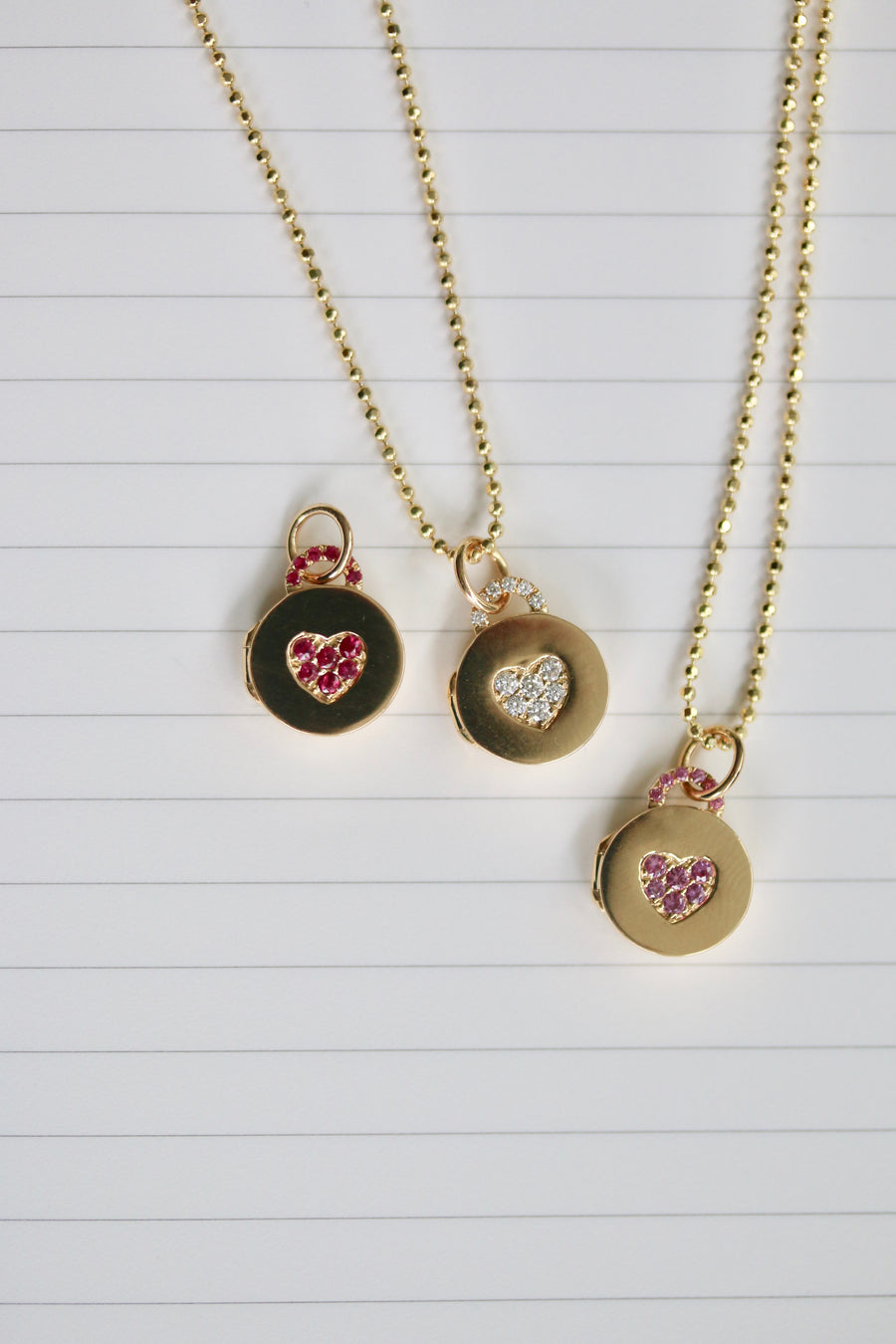 Mini heart-shaped locket pendant necklace adorned with pavé rubies, exuding elegance and charm. This dainty accessory features a delicate locket design encrusted with vibrant pavé rubies, adding a touch of glamour to any ensemble. The rich red hues of the rubies create a captivating contrast against the lustrous metal, making this necklace a statement of timeless beauty and sophistication.