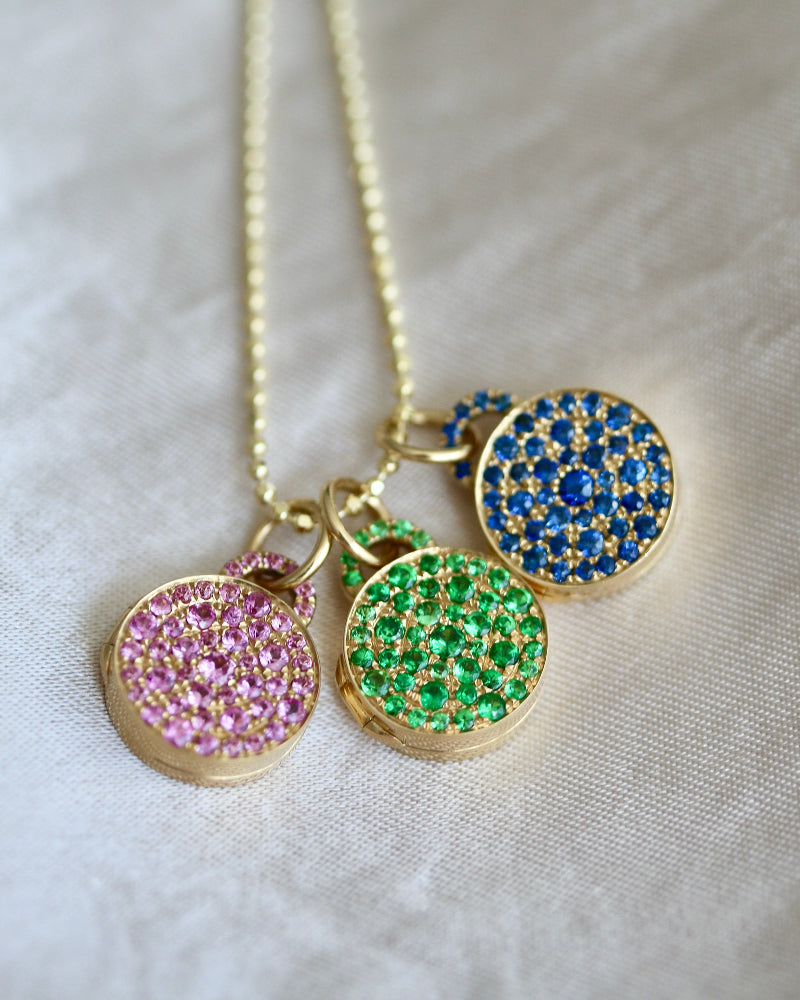 Necklace with colorful pendant charms on a light fabric background