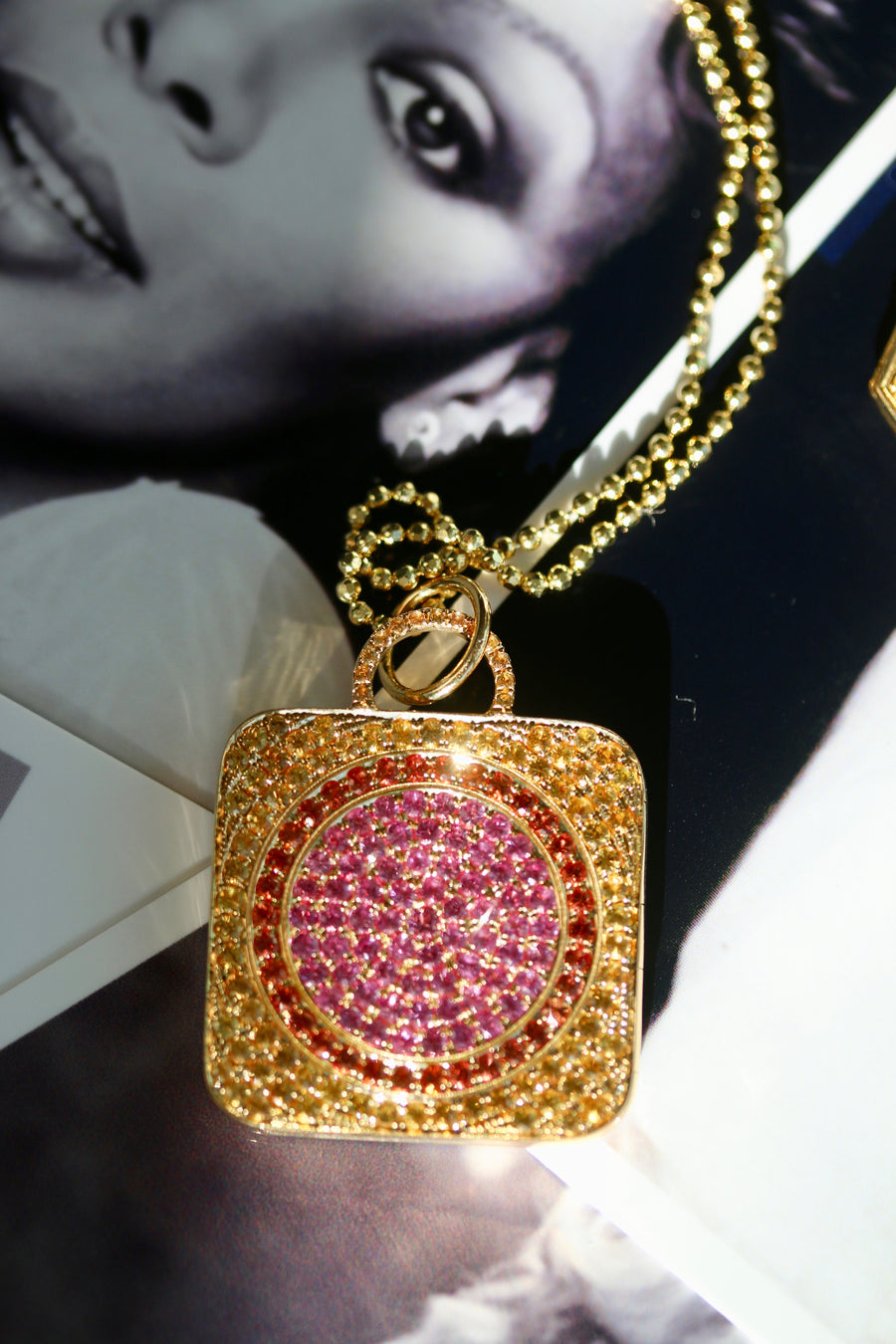 Square locket crafted in 18k gold, adorned with beautiful pink sapphires. This stunning piece features a contemporary design with intricate detailing and vibrant pink sapphire accents. The pink sapphires add a pop of color and elegance to the square locket, creating a unique and eye-catching accessory.