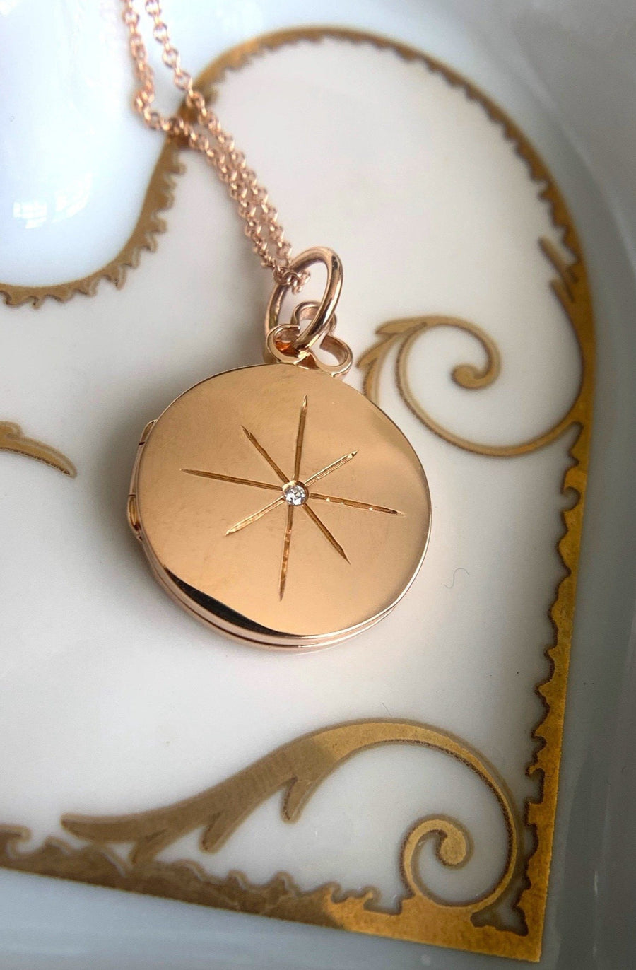 Round locket crafted in radiant 18k gold, showcasing a single diamond shimmering like the North Star. This enchanting piece evokes the celestial beauty of the night sky, with the diamond serving as a captivating focal point. The timeless elegance of the gold setting enhances the brilliance of the diamond, making this locket a symbol of celestial grace and sophistication.